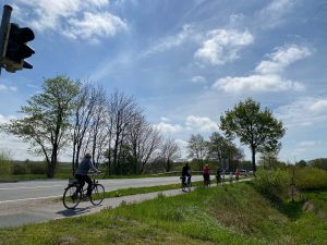 Radfahrer auf dem Radweg blauer Himmel Wolken und viel Grün Ostfriesland