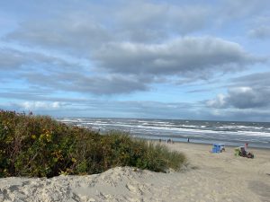 Blick auf den Strand und die Dünen Strandkörbe und Menschen Himmel mit Wolken